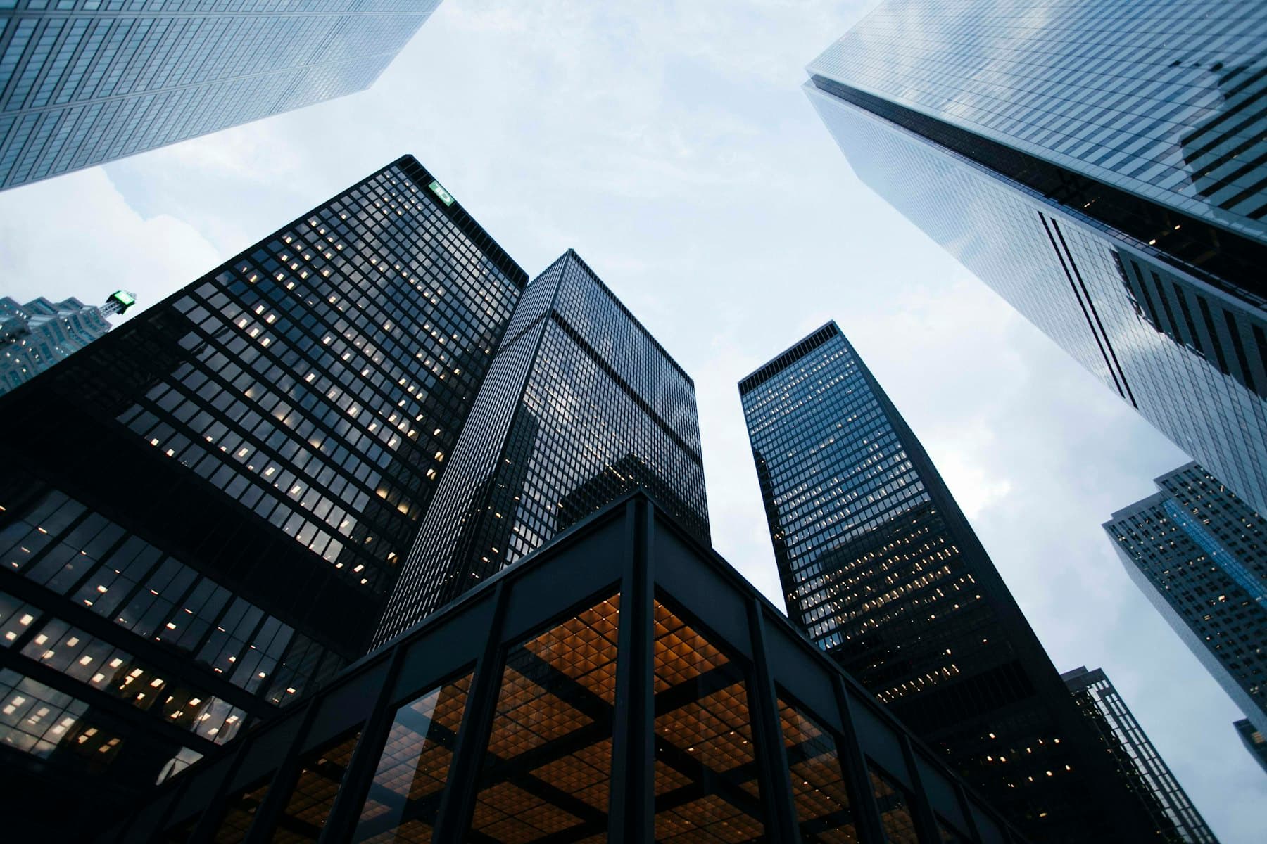 Looking up at dark glass office towers in a financial district