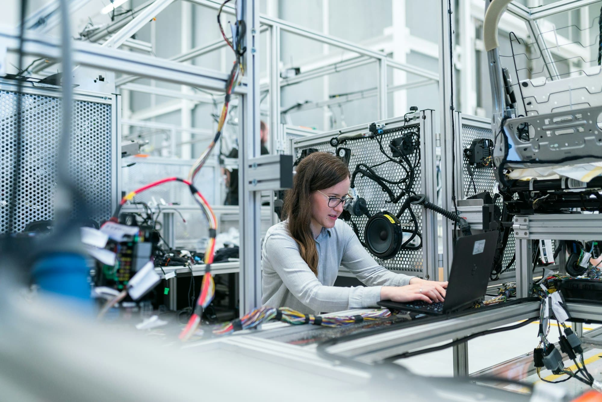 An engineer working at a laptop inside an automated production cell