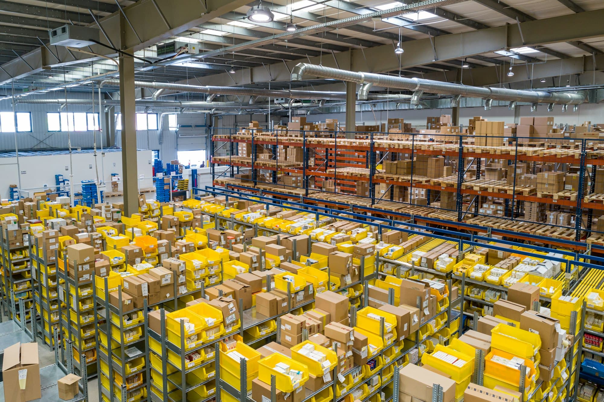 Rows of racking and yellow crates across the floor of a large distribution centre